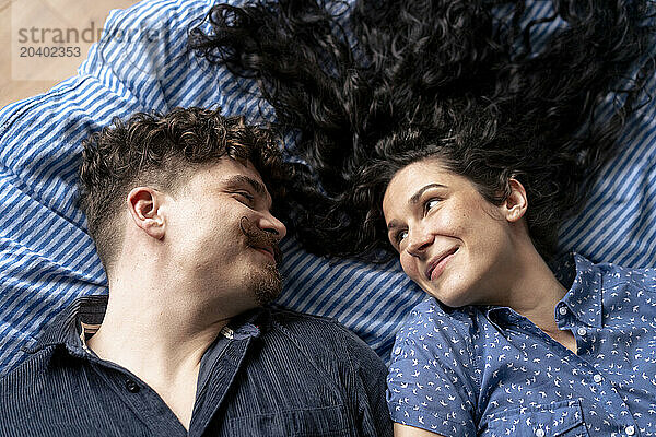 Romantic couple lying down on bed at home