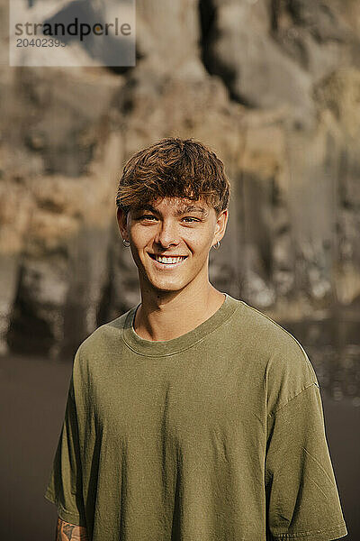 Smiling young man in T-shirt at beach