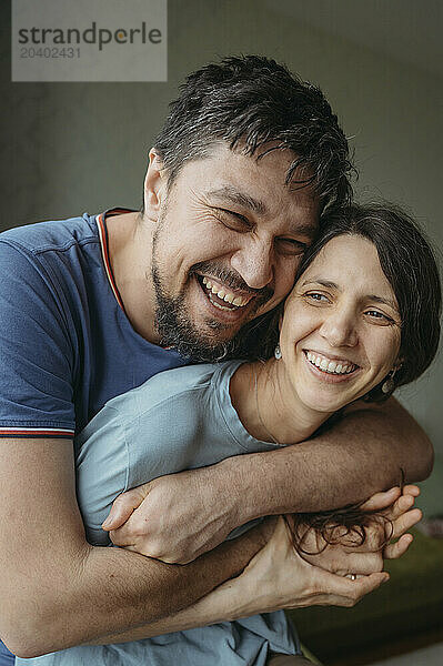 Happy man embracing woman at home