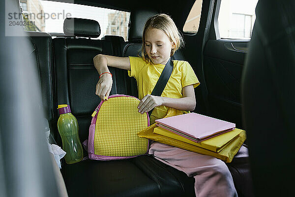 Girl wearing yellow t-shirt and packing bag in car