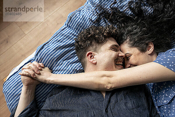 Affectionate couple lying down on bed at home