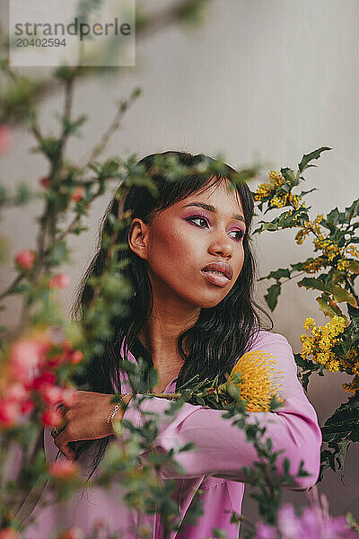 Thoughtful young woman amidts colorful flowers