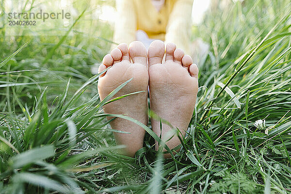 Girls feet over green grass in park