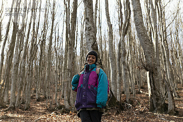 Smiling hiker standing in front of trees in forest