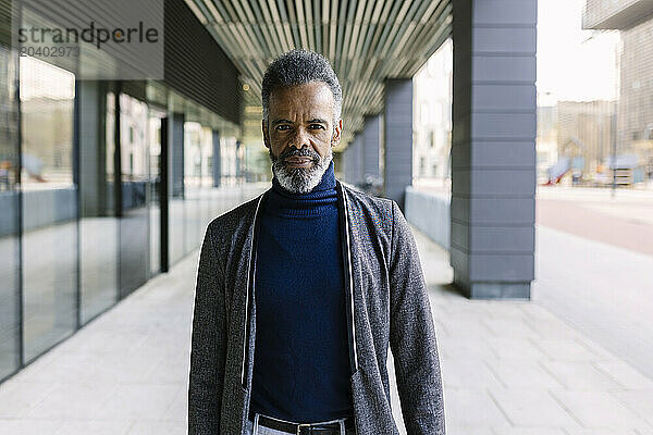 Mature businessman standing near building