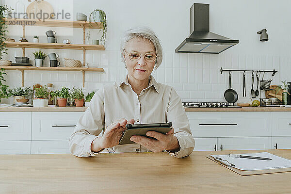 Woman surfing net on tablet PC at home