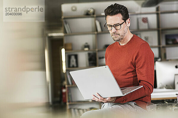 Dedicated businessman using laptop at office