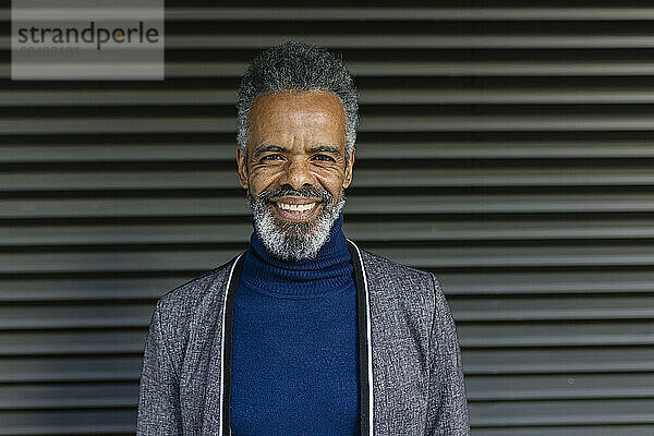 Happy mature businessman in front of shutter