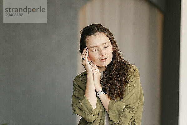 Woman with eyes closed standing in new home