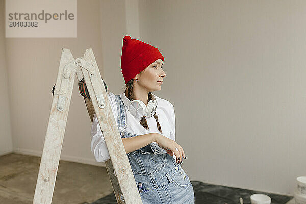 Woman leaning on ladder in new apartment