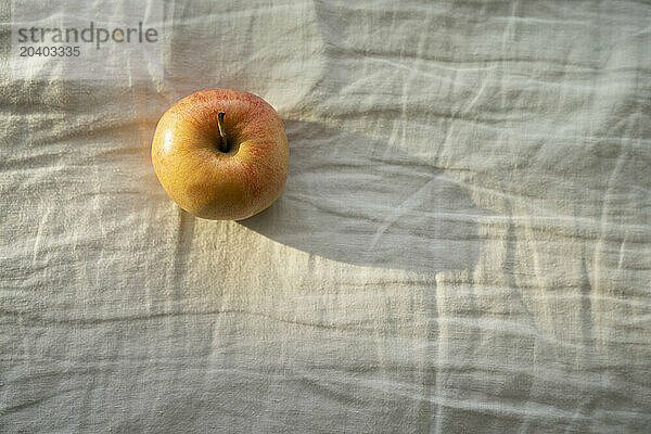 Apple lying on white colored cloth