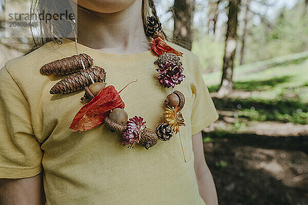 Girl wearing natural necklace standing in forest