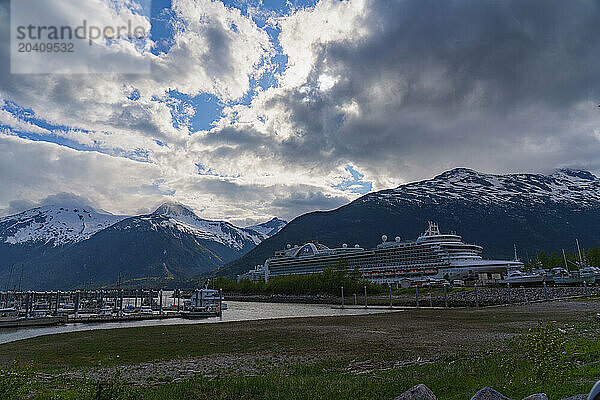 Cruise ships are seen docked at the Port of Skagway in southern Alaska. Large mountains adorn the landscape and make a scene that is magnificent to behold.