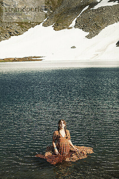 Teenage girl wearing a dress in Summit Lake at Hatcher Pass  Alaska