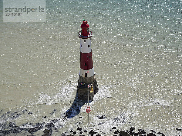 Beachy Head Lighthouse seen from the coast path above with glittering sea on a sunny day  East Sussex  UK © Renzo Frontoni