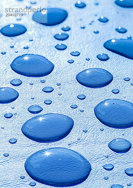 Close up of large waterdroplets on a blue background with a sun burst inside the waterdroplets