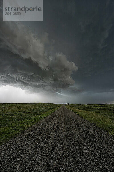 Dramatic clouds associated with a very strong supercell thunderstorm in Kansas. An old gravel road is here as the storm passes overhead.