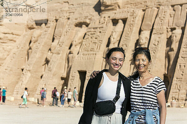 GAN 15482  Gan 15483  Mother and daughter tourists standing in front of the Temple of Hathor at Abu Simbel