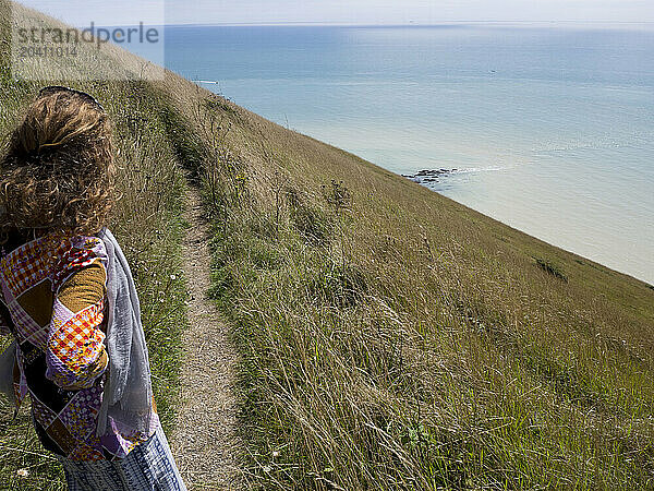 Woman looking at the sea from a coast path in the south of England near Beachy Head  Eastbourne  East Sussex  UK © Renzo Frontoni