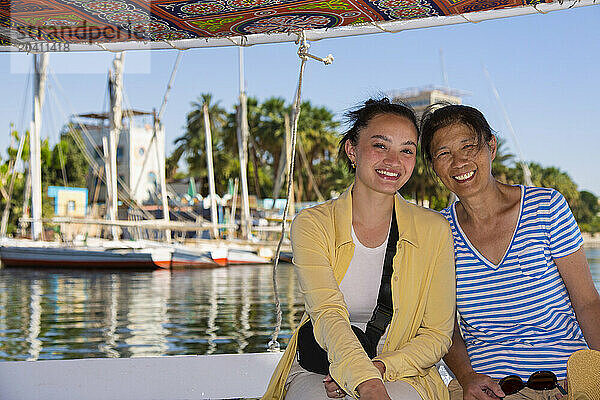 GAN 15482  Gan 15483  Mother and daughter tourists taking a Felucca ride on the Nile to the tombs of the Nobles Aswan Egypt