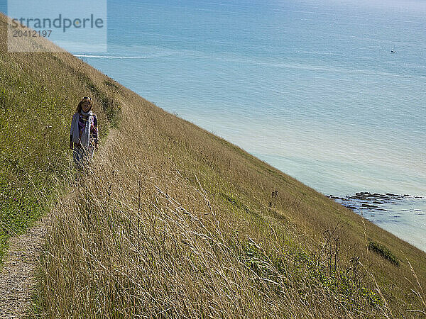 Woman walking on a coast path in the south of England near Beachy Head  Eastbourne  East Sussex  UK © Renzo Frontoni