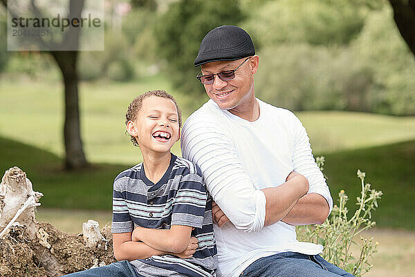 Fahter and son back to back laughing together