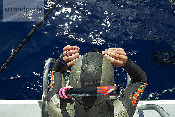 A safety diver prepares to help set up the diving platforms in the water before the morning's competition beings.