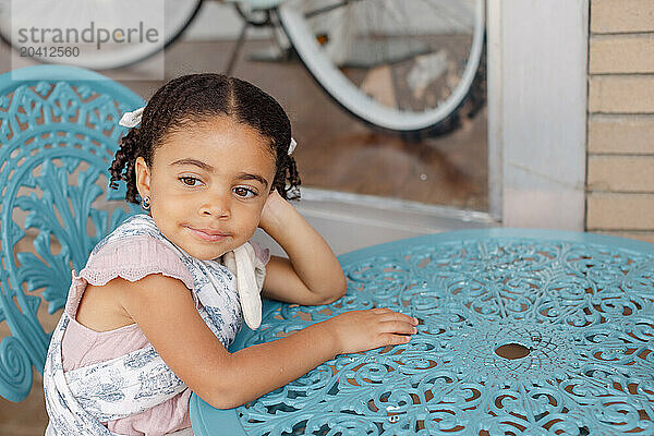 little girl enjoys summer while sitting outside a local boutique