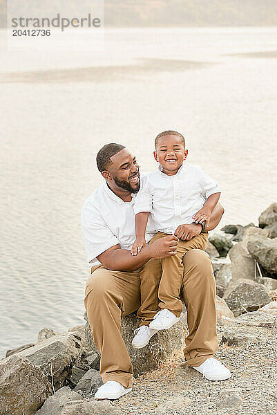 Father and son sitting together and laughing outside