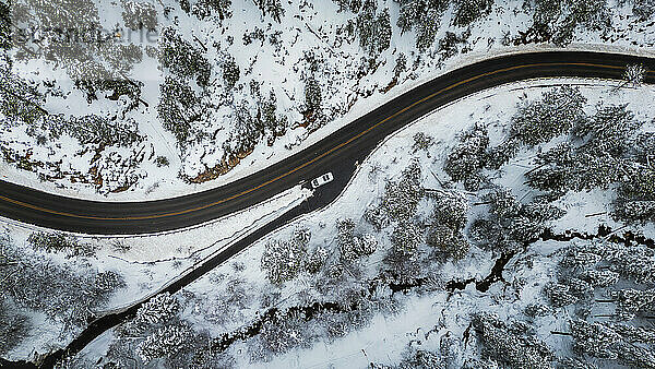 Winter road trip  white van on snowy Sedona path  aerial view