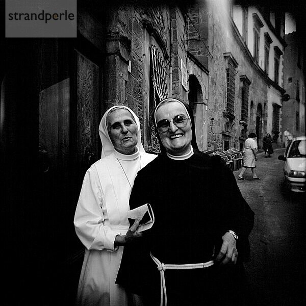 Two elderly nuns walk through the streets of Arezzo  Italy on their way to the market