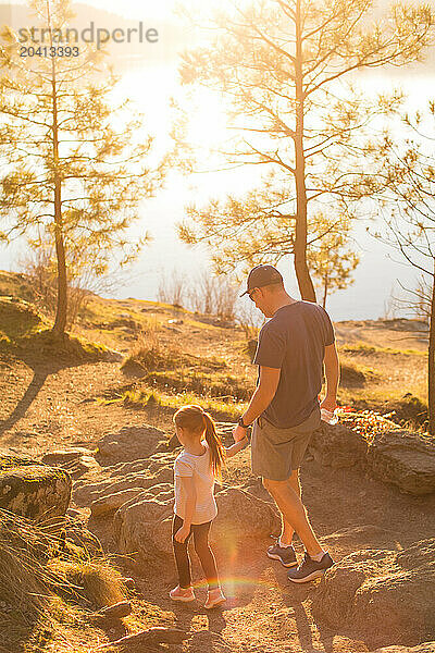 Father and daughter hiking overlooking lake