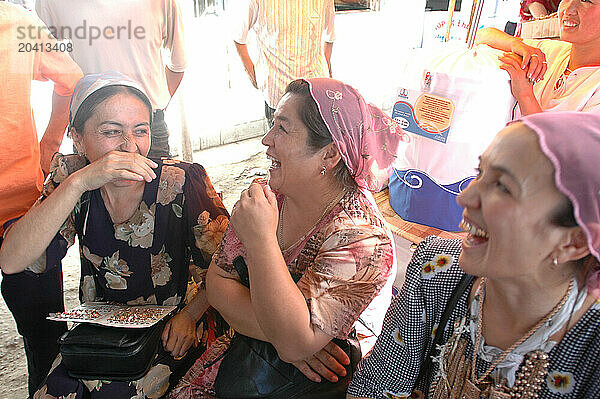 Women in traditional clothes laugh  Kyrgyzstan.