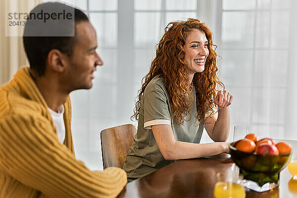 multiracial friends hanging out together at home sitting and chatting