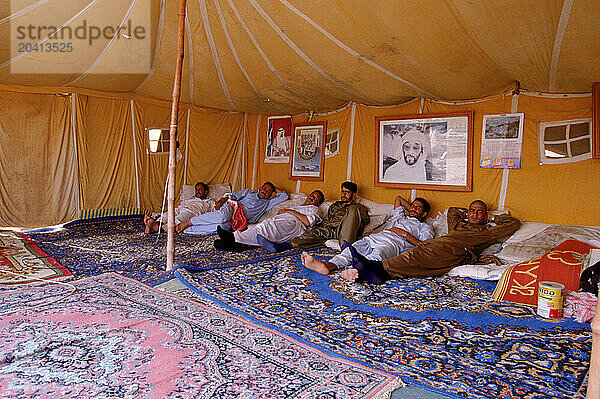 Men taking a break in a tent  Dubai  United Arab Emirates.