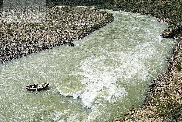 A boatman rows his dory clear of a big wave on the Colorado River in Grand Canyon National Park  Arizona.