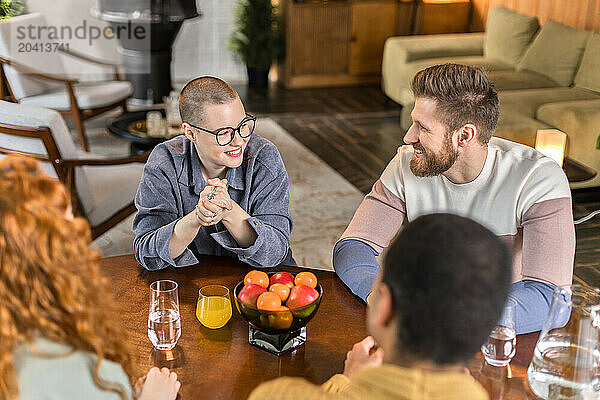 friends hanging out together at home sitting and chatting