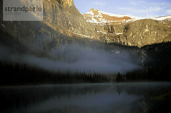 A lake reflects alpine peaks in Banff NP  Alberta Canada.