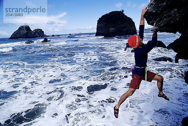 A boulderer in a cave above the ocean in Northern California