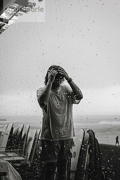 Young man walks in the rain.