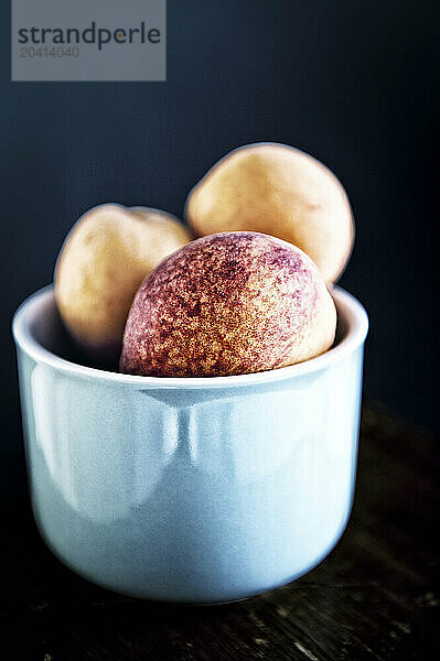 peaches in a blue bowl