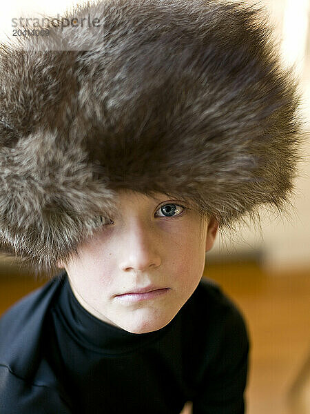 boy wears big fur hat