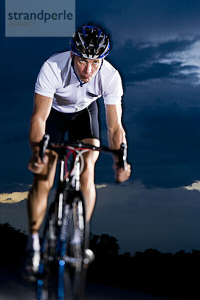 A cyclist in a white jersey rides during sunset in Lakeland  FL. (lit)(selective focus)