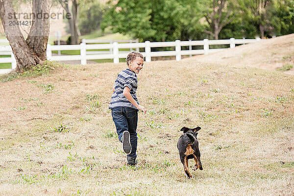 Boy and dog running together laughing