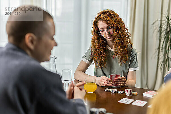 enjoying friends sitting at table and play card games