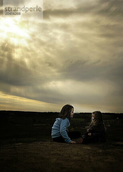 Beautiful sisters smiling and laughing outdoors at sunset