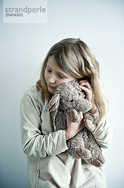 a young girl hugs her stuffed pig