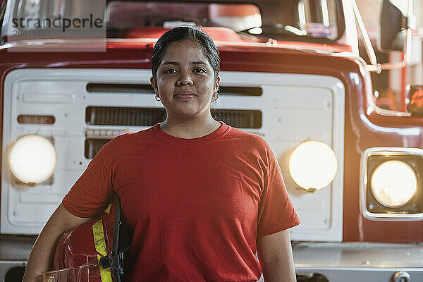 Portrait of smiling female firefighter standing at the fire station