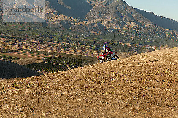 Skilled father and son riding dirt bike together in Santa Paula.