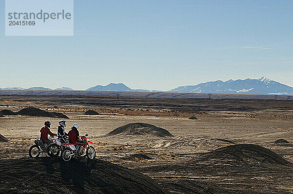 Young men take a break from riding dirt bikes during a motocross trip to the surreal dunes of the Painted Desert near Cameron  AZ.